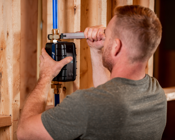 Man using a wrench to fit the pipes to the StreamLabs Control